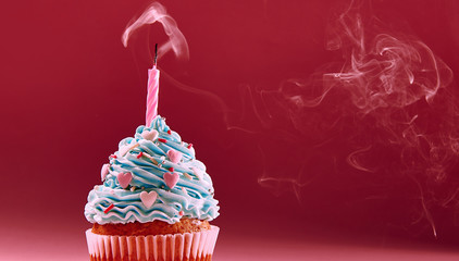 muffin with cream and extinguished candle. the concept of the end of the celebration.