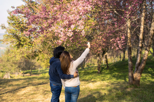 Loving couple traveler making selfie in the park