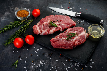 Fresh raw beef with spices  and tomatoes  on black background
