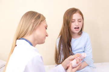 Female doctor checking hand of little patient. People with health care concept