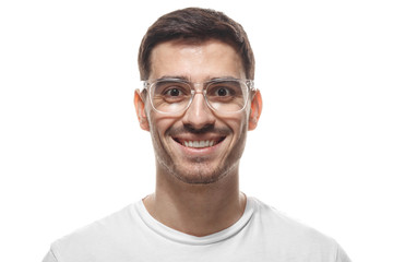 Obraz premium Close up headshot of smiling attractive man in white t-shirt and trendy trasparent eyeglasses isolated