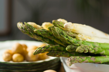 Raw uncooked fresh white and green asparagus with eggs and potatoes, ready to cook for dinner
