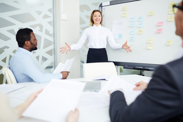 Successful manager making presentation of new project to young specialists