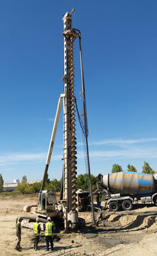 concrete fundation pile under construction: drill machine on site
