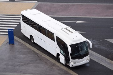 Ein großer, weißer, moderner Reisebus am Taxistand
