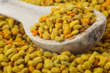 Flower bee pollen and a wooden spoon. Natural remedy for immunity enhancement. Beekeeping products. Apitherapy.