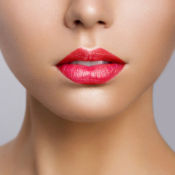Sexual full lips. Natural gloss of lips and woman's skin. The mouth is closed. Increase in lips, cosmetology. Red lips and long neck.