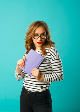 Pretty student with book wearing glasses over blue background