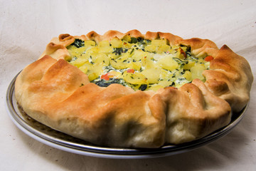 baked salad vegan cake with potatoes, spinach, carrots with puff pastry