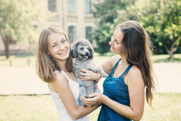 Happy young women hugging dog and  relaxing in the park.