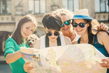 Women in sunglasses on vacation using the city map and exploring the locations. Concept of tourism
