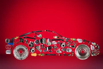 Passenger car assembled from new spare auto parts for shop aftermarket. Isolated on red background.