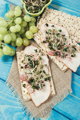 Healthy diet. Sandwiches with ham and broccoli sprouts on crisp bread.