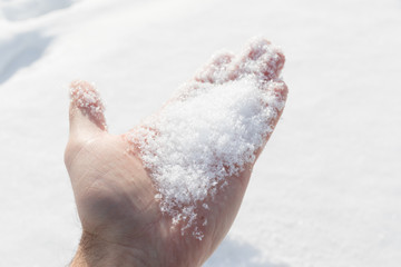 Snow on the hand on a sunny winter day