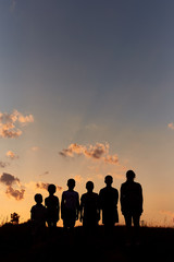 Six childrens stand on the field with sunset background sky