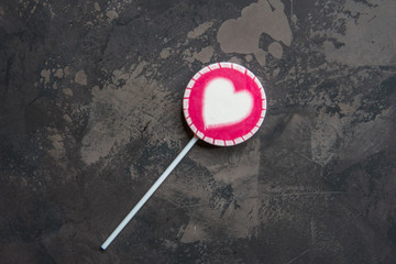 Pink lollipop with white heart top view