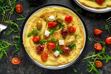 Vegetables Eggs Omelette with tomatoes, wild rocket, greek cheese, olives in a plate. Morning breakfast. healthy food