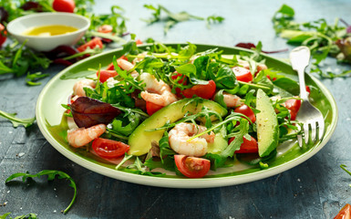 Fresh Avocado, shrimps salad with lettuce green mix, cherry tomatoes, herbs and olive oil, lemon dressing. healthy food