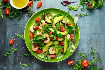 Fotobehang Gerechten Verse Avocado, garnalensalade met groene slamix, cherrytomaatjes, kruiden en olijfolie, citroendressing. gezond eten
