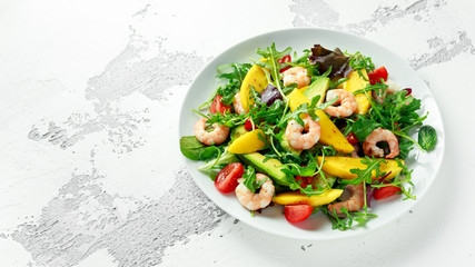 Fresh Avocado, Shrimps, Mango salad with lettuce green mix, cherry tomatoes, herbs and olive oil, lemon dressing. healthy food