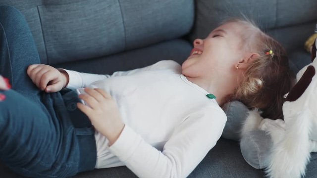 Close up hand happy mother having fun with kid daughter tickling on sofa home woman baby love child girl face young cheerful little beautiful joy smile childhood cute together laugh lying activities