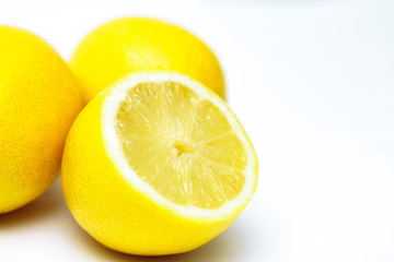 Fototapeta na wymiar three yellow lemon one in a cut on a white background