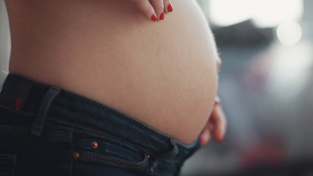 Close up hand woman touching her pregnant belly sunlight baby love child girl pregnancy mother motion waiting slow female parenthood healthy young abdomen anticipation beautiful beauty motherhood