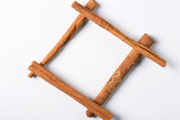 Frame made of cinnamon sticks on a white background.