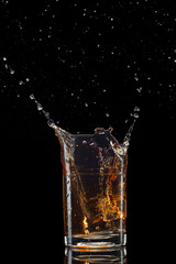 Isolated shot of whiskey with splash on black background