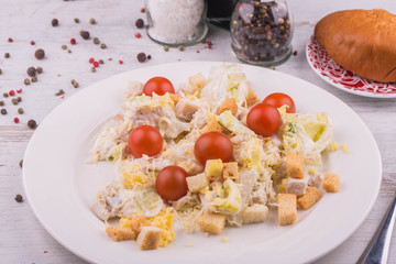 Caesar Salad with cherry tomatoes, croutons and pieces of chicken meat