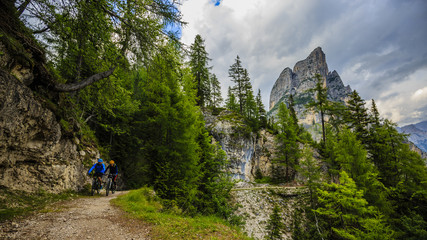 Mountain biking couple with bikes on track, Cortina d'Ampezzo, Dolomites, Italy