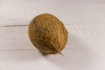 Whole coconut on white wooden table