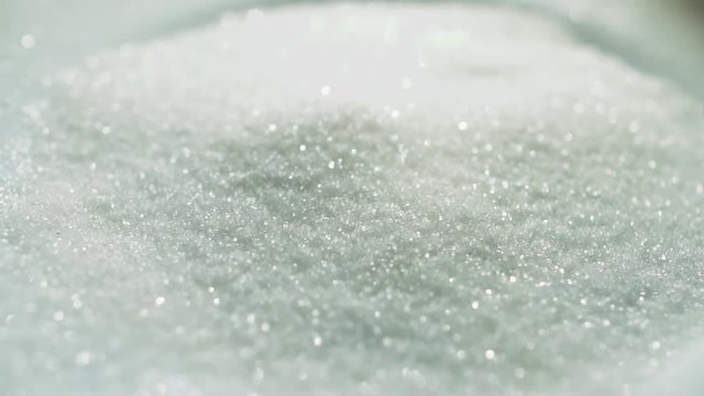 Scratches of sugar slowly piling on the pile. Crystallized white sugar, studio video