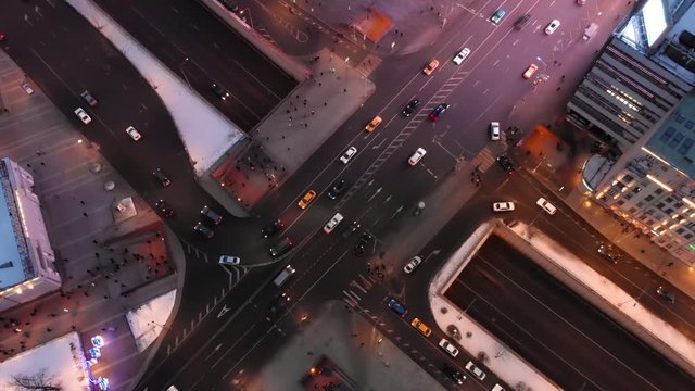Aerial night urban traffic scene, late evening Moscow traffic junction crossroad, intense transport highway load, people walking along street.