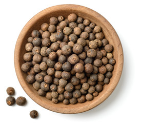 dried herb, allspice in the wooden plate. isolated on white, top view - obrazy, fototapety, plakaty