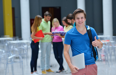 Portrait of a young student standing outside with friends in the background