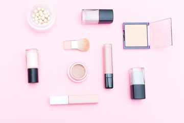 Obraz premium Nude cosmetics and makeup tools on pink background. Flat lay