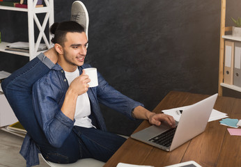 Flexible man practicing yoga at workplace