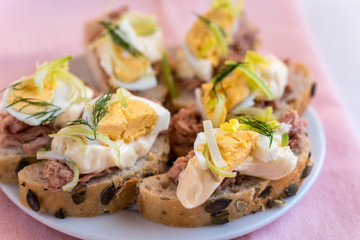 Bruschetta, snack sandwiches with tuna, egg and mayonnaise decorated by dill.