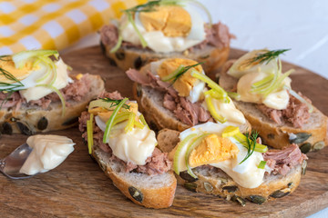 Bruschetta, snack sandwiches with tuna, egg and mayonnaise decorated by dill.