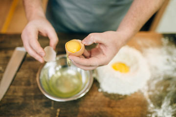 Pasta cooking process, male chef hands with egg