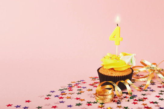 Fourth birthday cupcake with candle and sprinkles