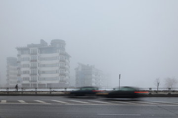 Mystical landscape of residential low-rise houses in dense fog