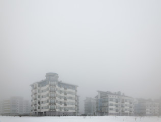 Fototapeta premium Mystical landscape of residential low-rise houses in dense fog