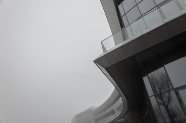 Abstract architectural background. Element of the facade of a modern building in dense fog