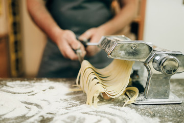 Chef cooking fettuccine in pasta machine