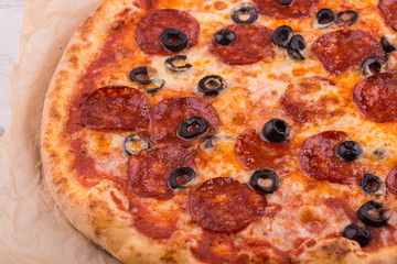 Salami pizza and the cut olives under cheese