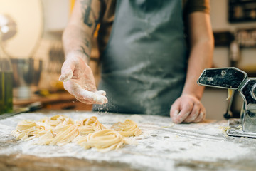 Chef against kitchen table with homemade pasta