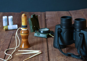Preparing for the duck hunt. Manok, compass, binoculars, cartridges.
