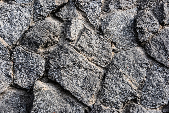 Textured grunge wall of sharp stones with sand